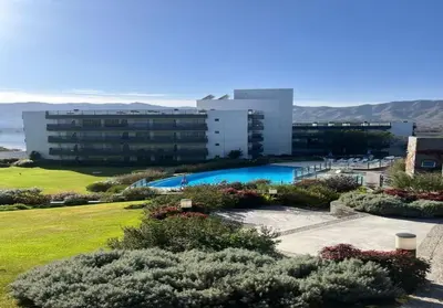 a building with a swimming pool in front of a building at Veneto Village - Vista al Lago - 10 minutos a Carlos Paz in Villa Parque Siquiman