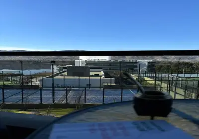a table with a view of a factory from a window at Veneto Village - Vista al Lago - 10 minutos a Carlos Paz in Villa Parque Siquiman