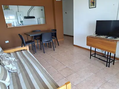 a living room with a table and chairs and a television at Espacio C Av Poeta Lugones GRAN VISTA in Cordoba