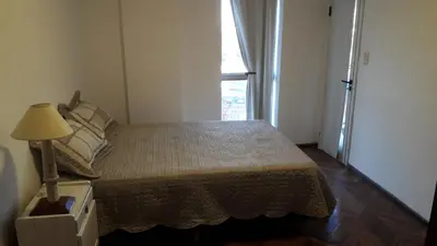 a bedroom with a bed with a lamp and a window at Espacio C Av Poeta Lugones GRAN VISTA in Cordoba