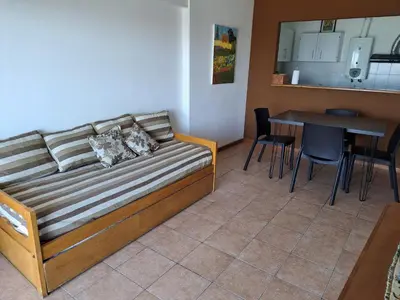 a couch in a room with a table and a kitchen at Espacio C Av Poeta Lugones GRAN VISTA in Cordoba