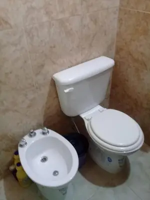 a bathroom with a white toilet and a sink at Cabaña de Emma in Villa de Las Rosas