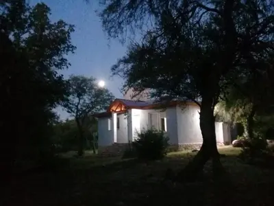 a small white house with a moon in the sky at Cabaña de Emma in Villa de Las Rosas