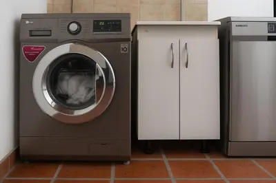 a washing machine sitting next to a white cabinet at Atenea Residence in Cordoba