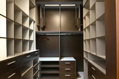 a walk in closet with black and white cabinets at Atenea Residence in Cordoba
