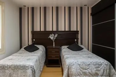 a bedroom with two beds and a vase of flowers at Atenea Residence in Cordoba