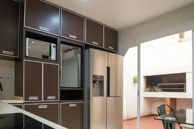 a kitchen with black cabinets and a stainless steel refrigerator at Atenea Residence in Cordoba