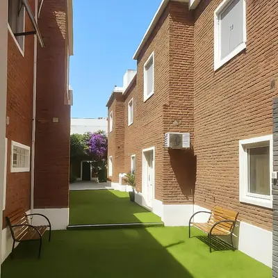 a courtyard with two benches and a brick building at Atenea Residence in Cordoba