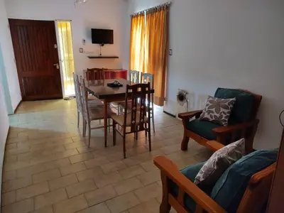 a living room with a table and chairs and a couch at Depto del Lago in Villa Carlos Paz