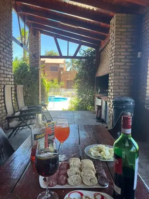 a wooden table with two glasses of wine and food at Depto del Lago in Villa Carlos Paz
