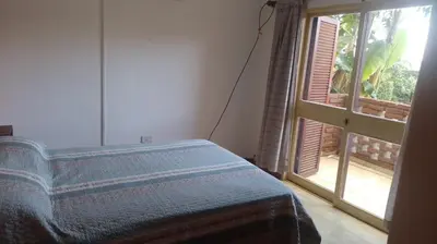 a bedroom with a bed and a large window at Depto del Lago in Villa Carlos Paz