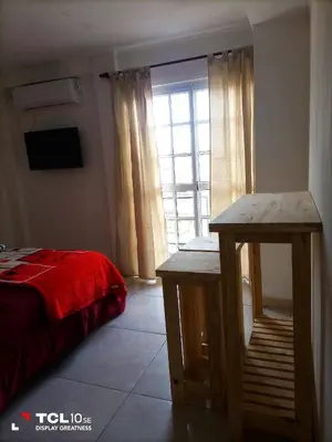 a bedroom with a red bed and a window at Departamentos Los Almendros in Merlo