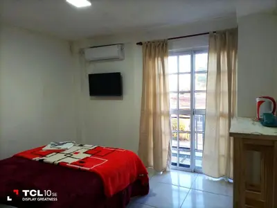 a bedroom with a bed and a large window at Departamentos Los Almendros in Merlo