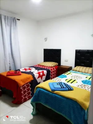 a bedroom with two beds with colorful blankets at Departamentos Los Almendros in Merlo