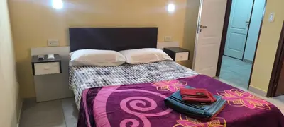 a bedroom with a large bed with a purple blanket at Departamentos Los Almendros in Merlo