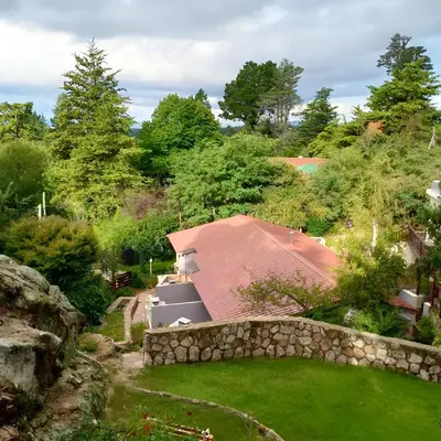 a house with a red roof and a stone wall at Casa Kuhstall in La Cumbrecita