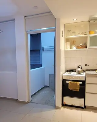 a kitchen with a stove and a door leading to a bathroom at La mejor ubicación para alojarte! in Cordoba