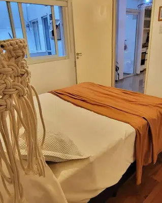 a bed in a room with a large window at La mejor ubicación para alojarte! in Cordoba