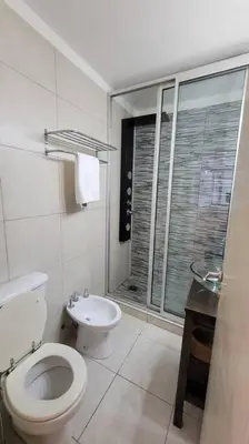 a white bathroom with a toilet and a sink at La mejor ubicación para alojarte! in Cordoba