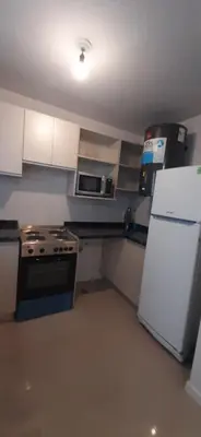 a kitchen with a stove and a white refrigerator at Torre Opera Depto 3º B in Villa Carlos Paz