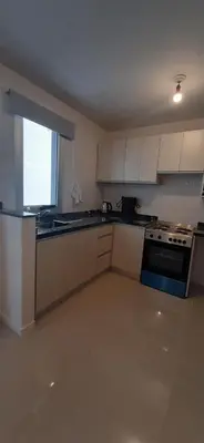 a kitchen with white cabinets and a stove at Torre Opera Depto 3º B in Villa Carlos Paz