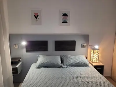 a bedroom with a bed with three pictures on the wall at Torre Opera Depto 3º B in Villa Carlos Paz