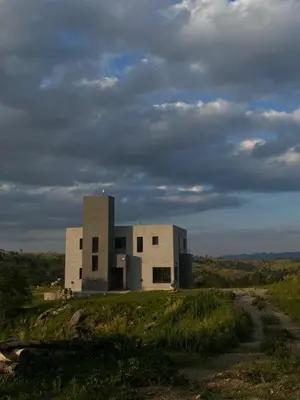 a building sitting on top of a grassy field at Casal Sur in Potrero de Garay