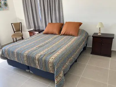 a bedroom with a bed and a table and a chair at Casal Sur in Potrero de Garay
