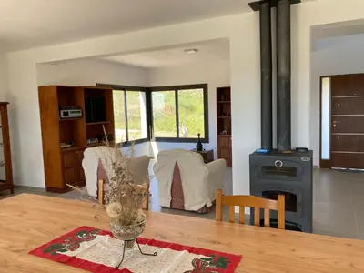 a living room with a table and a stove at Casal Sur in Potrero de Garay
