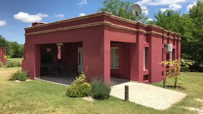 a red building with a patio in the grass at Casonas de Nono in Nono