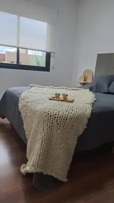 a bedroom with a bed with a blanket on it at Alma Serrana VGB in Villa General Belgrano