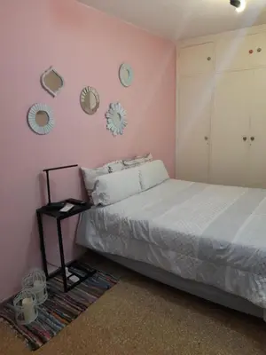 a bedroom with a bed and a pink wall at Mi lugar, tu lugar in Cordoba
