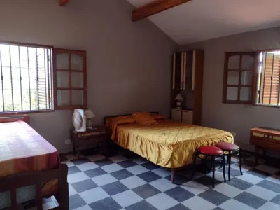 a bedroom with a bed and two stools in it at Complejo La Tere- depto 1 in Cordoba