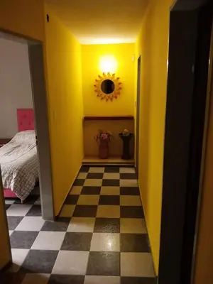 a yellow hallway with a checkered floor and a mirror at Complejo La Tere- depto 1 in Cordoba