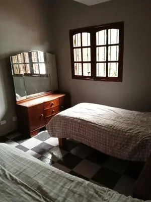 a bedroom with two beds and a dresser and two windows at Complejo La Tere- depto 1 in Cordoba