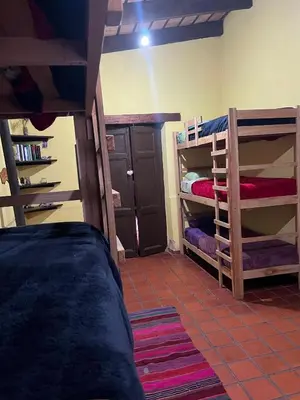 a room with two bunk beds and a room with a closet at Hostel del pueblo in Amboy