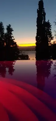 a sunset over a body of water with trees at Vista Alago in Villa Ciudad Parque