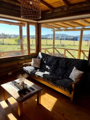 a living room with a black couch and a table at Cabaña La Maura in La Estancia