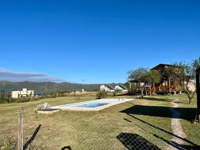 a yard with a swimming pool and a house at Cabaña La Maura in La Estancia