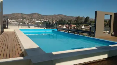 a large swimming pool on top of a building at Depto en pleno centro con pileta, cochera, hermosa vista in Villa Carlos Paz