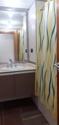 a bathroom with a sink and a shower curtain at Depto en pleno centro con pileta, cochera, hermosa vista in Villa Carlos Paz
