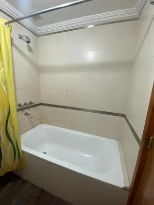 a white tub in a bathroom with a shower at Depto en pleno centro con pileta, cochera, hermosa vista in Villa Carlos Paz