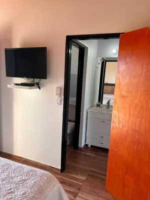 a bedroom with a bed and a mirror and a television at El 8 del mirador in Villa Santa Cruz del Lago