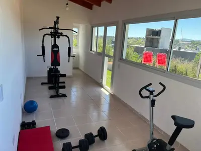 a room with a gym with weights and a window at El 8 del mirador in Villa Santa Cruz del Lago