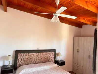 a bedroom with a ceiling fan and a bed at El 8 del mirador in Villa Santa Cruz del Lago