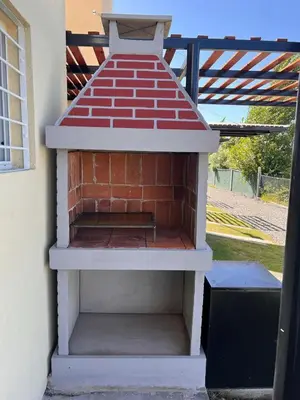 a brick oven sitting next to a building at El 8 del mirador in Villa Santa Cruz del Lago
