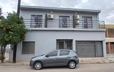 a silver car parked in front of a white house at Tempo Suites in Cordoba