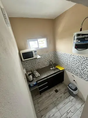 a small kitchen with a sink and a microwave at Tempo Suites in Cordoba
