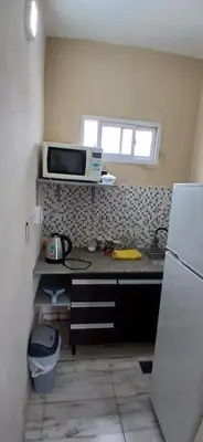 a kitchen with a counter with a microwave and a refrigerator at Tempo Suites in Cordoba