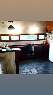 a kitchen with a stove and a refrigerator at Cabaña Los Espinillos in Cortaderas